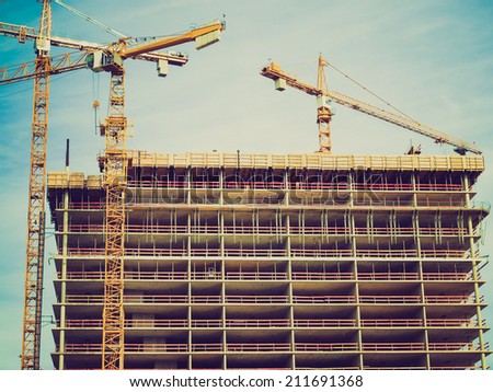 Vintage retro looking Construction cranes at a building site