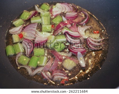 Celery and red onions in a frying pan