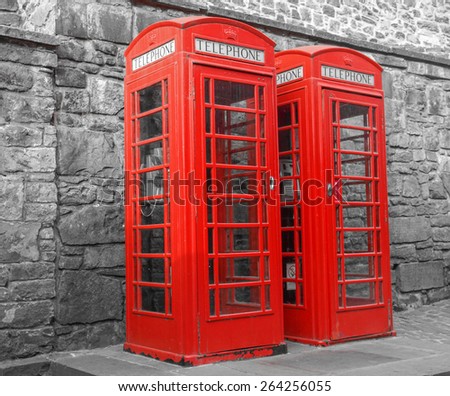 Red telephone box in London over desaturated black and white background