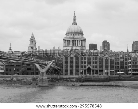 LONDON, UK - JUNE 10, 2015: People crossing the Millennium Bridge linking the City of London with the South Bank between St Paul Cathedral and Tate Modern art gallery in black and white
