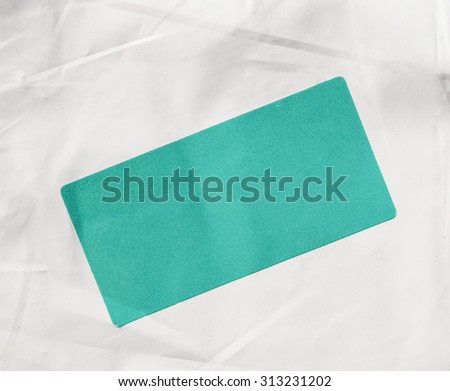 A green paper tag label sticker on a white envelope for mail with copy space