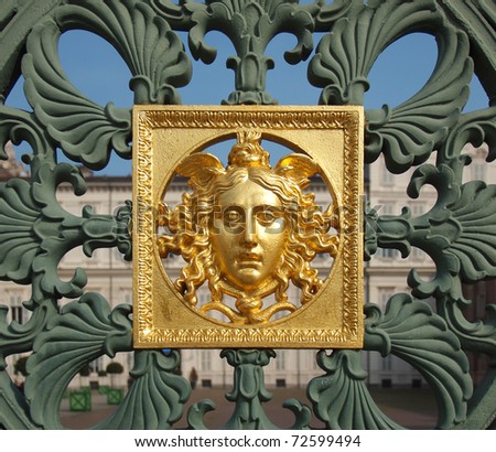 Ancient baroque golden mask on a fence, Palazzo Reale, Turin, Italy