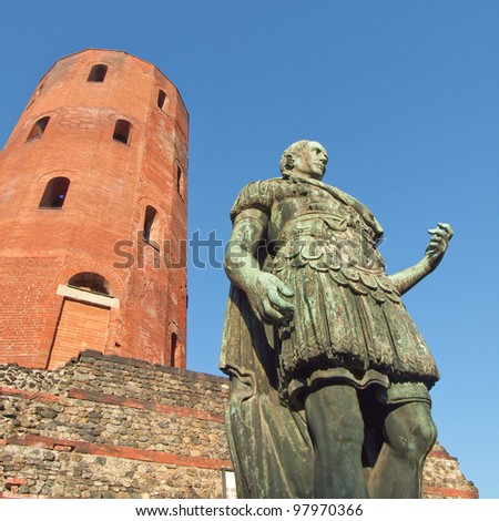 Ancient roman statue of emperor Augustus in front of Porte Palatine city gates, Turin, Italy