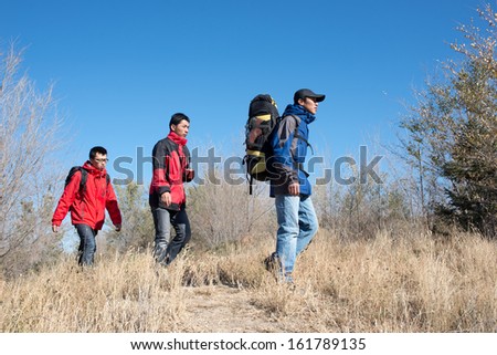 A group of people with backpacks walking along the road.