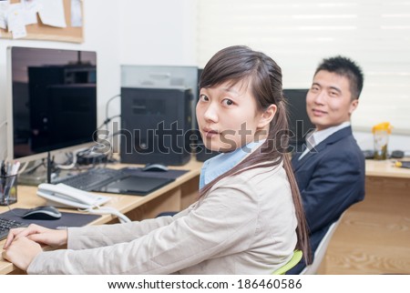 Two business people sitting at computer. The focus is on woman