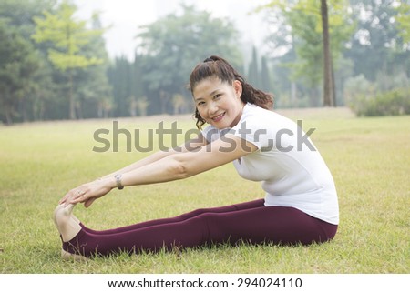 Older woman exercise fitness workout. On the Park Lawn