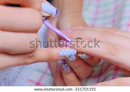 Closeup Of Manicurist Holding Woman\'s Hand Applying Nail Varnish