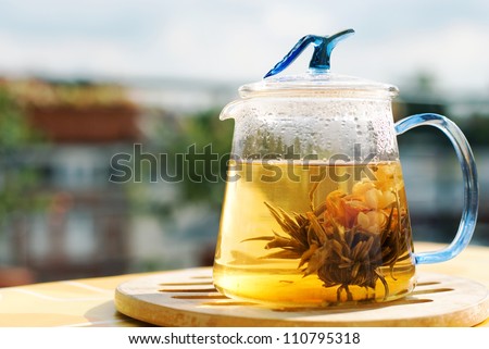 Teapot with green tea on the table, on terrace outdoor