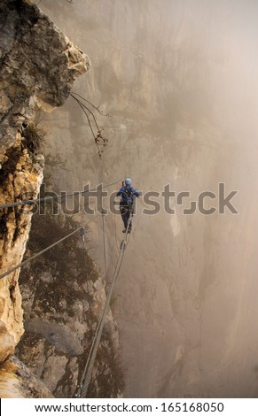 man on a suspension path in via-ferrata activity