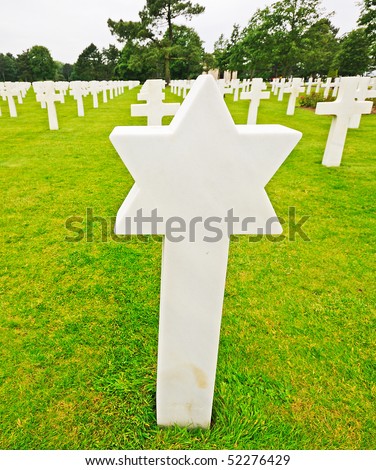 Star of David grave marker with Cross markers in a military cemetery.