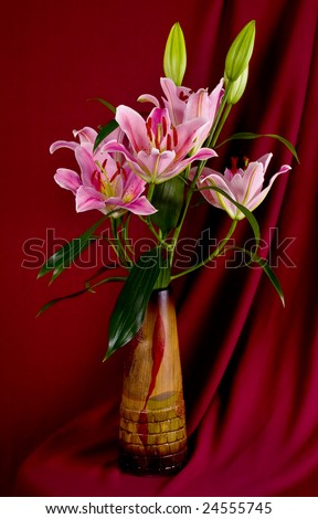 bouquet lily in wooden vase draped by fabrics