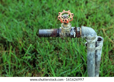 Water valve and steel pipe, old rusty industrial tap water pipe and valve.
