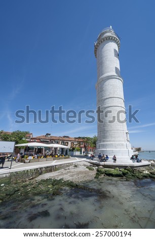 Venice, Italy - May 8, 2014: Lighthouse on Murano island in Venice, Italy. Murano is  well known immaculate glass art work. For visitors to Venice, it is a well known and visited destination.