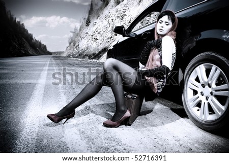 beautiful woman with baggage near the car