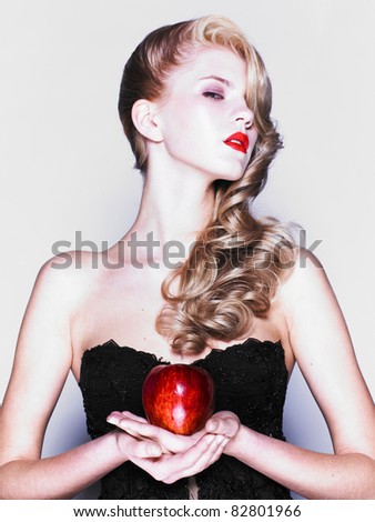 Young pretty woman in a fashionable dress with apple