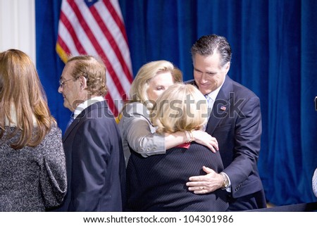 LAS VEGAS - FEB 2: Mitt and Ann Romney hug an unidentified person at the Trump hotel on February 2, 2012 in Las Vegas, Nevada. Donald Trump has endorsed Romney for president.