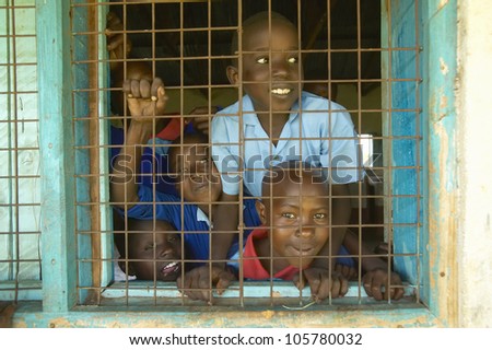 JANUARY 2005 - Children in blue uniforms in window at school near Tsavo National Park, Kenya, Africa