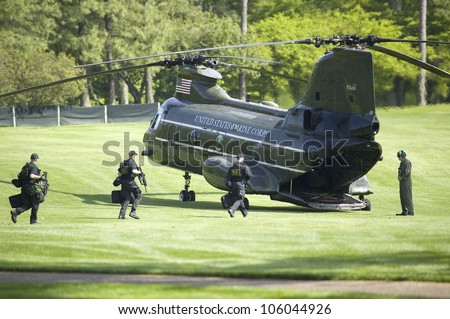 Secret Service guards running to Presidential Helicopter for takeoff on green golf course in Williamsburg, Virginia, May 4, 2007