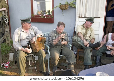 German soldiers relaxing during World War II reenactment with musical instruments at French Village at Mid-Atlantic Air Museum World War II Weekend and Reenactment in Reading, PA held June 18, 2008