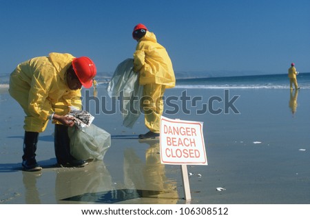 CIRCA 1990 - Hazardous material workers cleaning up oil spill, Huntington Beach, CA