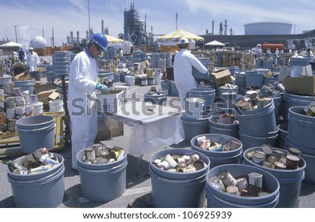 CIRCA 1990 - Workers handling toxic household wastes at waste cleanup site on Earth Day at the Unocal plant in Wilmington, Los Angeles, CA