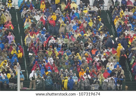 Rain gear clad guests attend the official opening ceremony of the Clinton Presidential Library November 18, 2004 in Little Rock, AK