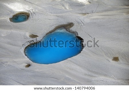 Aerial view of silt and turquoise water in an Alaska glacier, Alaska