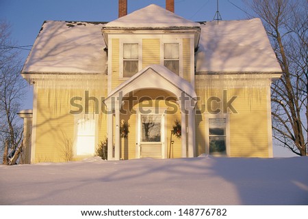 VERMONT - CIRCA 1980\'s: Home covered in icicles and snow at sunrise, Vermont