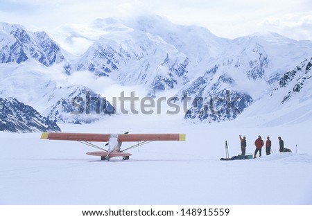 WRANGELL MOUNTAINS, WRANGELL, ALASKA  - CIRCA 2001: Mountain climbing team and airplane in Wrangell Mountains in St. Elias National Park and preserve, Alaska