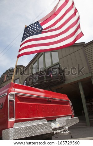 US Flag flies over old red chevrolet pickup truck, July 4 2013 Independence Day Parade, Ouray, Colorado