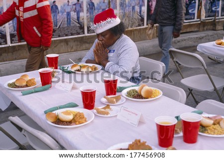 A woman giving thanks for her Christmas dinner, Los Angeles Mission, CA