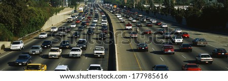 This is rush hour traffic on the 405 Freeway at sunset. There are 10 total lanes of traffic with cars traveling in both directions.