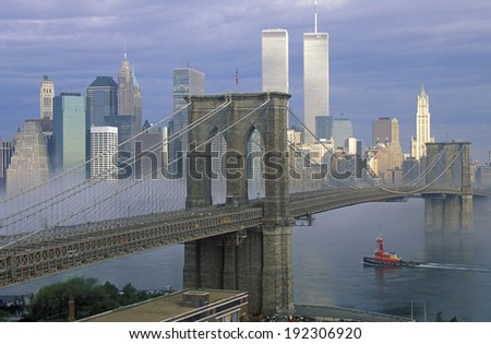 View of New York skyline, Brooklyn Bridge over the East River and tugboat in fog, NY