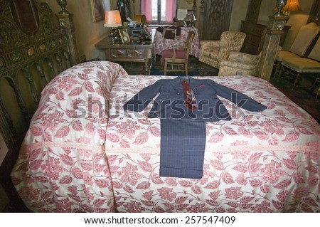 Interior of guest bedroom with displayed antique clothing of the day at Hearst Castle, \