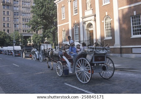 Horse and carriage riding in historic district of old Philadelphia, PA, in front of Independence Hall, home of Declaration of Independence and US Constitution
