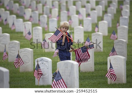 Cubscout places one of 85, 000 US Flags at 2014 Memorial Day Event, Los Angeles National Cemetery, California, USA, 05.24.2014
