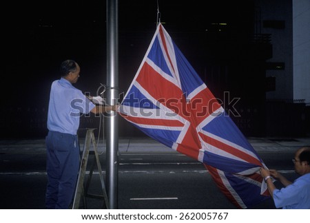 Man lowering British Union Jack flag in Hong Kong