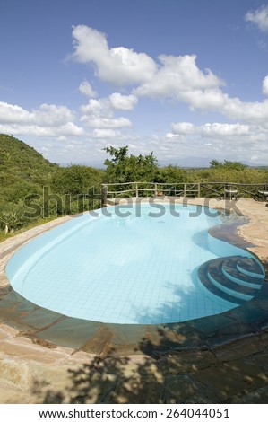 Swimming pool with turquoise water surrounded by the hills of North Kenya, Africa at the Lewa Wildlife Conservancy