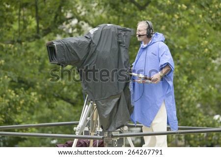 Television cameraman in blue raincoat video taping opening ceremonies of the arrival of Her Majesty Queen Elizabeth II in Richmond Virginia, May 3, 2007