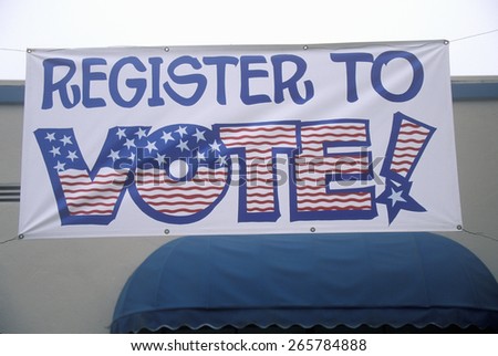 Large hand painted sign reads Register to Vote