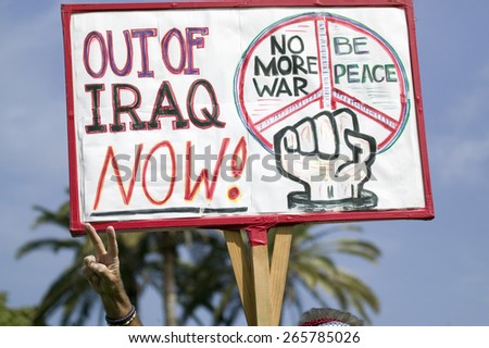 A man gives the peace sign and holds a sign saying, \
