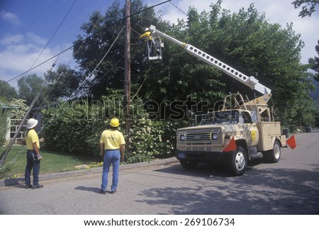 Cable television repairmen using a cherry-picker, Ojai, CA