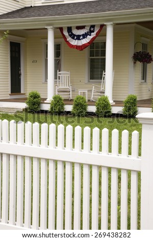 Two rocking chairs on porch in front of white picket fence on Memorial Day, 2011, outside of Lexington, MA