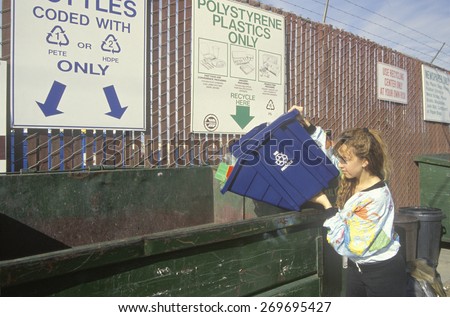 A woman recycling plastics in separate recycling containers at the Santa Monica Recycling Center, CA