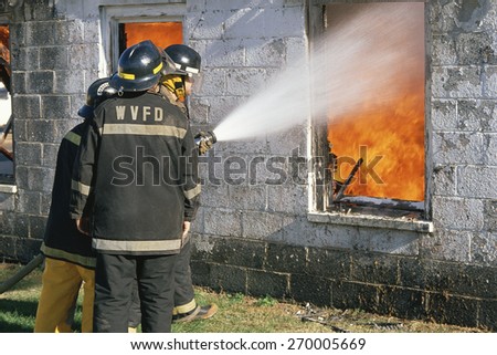 Fireman hosing down a burning building