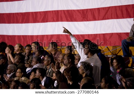African American woman standing in front of American Flag at Barack Obama Presidential Rally, October 29, 2008 in Rocky Mount High School, North Carolina