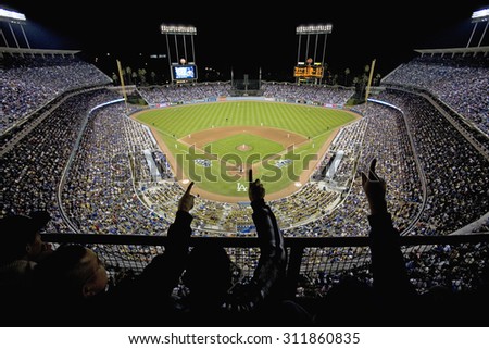 Silhouette of Dodger fans cheer and point from grandstands overlooking home plate at National League Championship Series (NLCS), Dodger Stadium, Los Angeles, CA on October 12, 2008