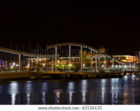 A general view of Barcelona port and bridge at night, with reflection lights on the water