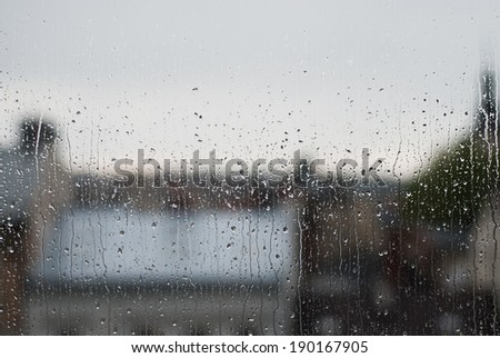 Raindrops on window, city as a background