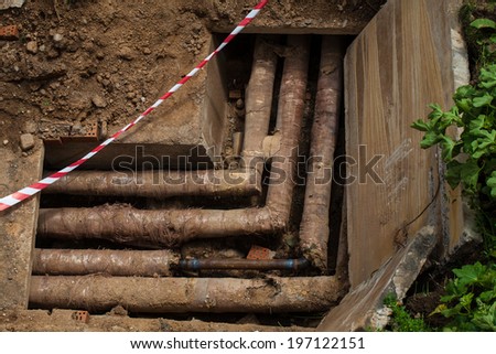 Concrete water trough metal pipes. Pit deep in the ground